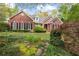 Brick home with beautiful landscaping featuring lush greenery and blooming plants at 1410 Daley Ridge Ct, Lawrenceville, GA 30045