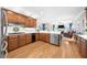 Open-concept kitchen with stainless steel appliances, wooden cabinetry and a breakfast bar that opens into the living area at 1410 Daley Ridge Ct, Lawrenceville, GA 30045