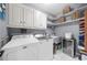Bright laundry room with white cabinetry, shelving, and a washer/dryer at 1410 Daley Ridge Ct, Lawrenceville, GA 30045