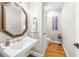 Classic powder room with hardwood floors, vintage mirror, and pedestal sink at 1410 Daley Ridge Ct, Lawrenceville, GA 30045