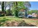 View of home's exterior features a well-maintained lawn, mature trees, and green siding at 2538 Three Bars Drive, Grayson, GA 30017