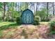 Charming shed in a verdant backyard, offering additional storage and character to the property at 2538 Three Bars Drive, Grayson, GA 30017