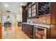 This bar area features beautiful wood cabinets with a wine rack, granite countertops, and a wine cooler at 5473 Heyward Square Pl, Marietta, GA 30068