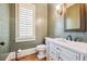 Charming powder room featuring a white vanity, hardwood floors, and designer wallpaper at 5473 Heyward Square Pl, Marietta, GA 30068