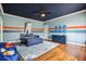 This bedroom has blue walls and ceiling, wood floors, and a rug with a solar system pattern at 5473 Heyward Square Pl, Marietta, GA 30068