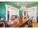 Formal dining room with green walls, decorative trim, and a large wooden table at 5473 Heyward Square Pl, Marietta, GA 30068