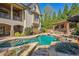 Custom pool and spa with waterfall feature, lush landscaping, and an outdoor kitchen and bar area at 5473 Heyward Square Pl, Marietta, GA 30068