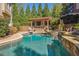 Inviting outdoor space features a stone-trimmed pool, hot tub, waterfall, and covered patio with a stone fireplace at 5473 Heyward Square Pl, Marietta, GA 30068