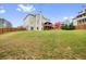 Spacious backyard with lush green grass, a wooden fence, and a playhouse with a deck at 603 Redcoat Cir, Canton, GA 30114