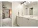 Bathroom features a double sink vanity and updated lighting, leading into a room with pink window curtains at 603 Redcoat Cir, Canton, GA 30114