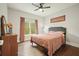 Cozy bedroom features hardwood floors, a ceiling fan, and a large window at 603 Redcoat Cir, Canton, GA 30114