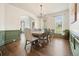 Bright dining room with hardwood floors, wainscoting, and modern light fixture at 603 Redcoat Cir, Canton, GA 30114