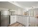 Modern kitchenette with stainless steel refrigerator, white cabinetry, and granite countertops at 603 Redcoat Cir, Canton, GA 30114