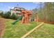 Backyard features a wooden playset with a slide and swings for outdoor fun at 603 Redcoat Cir, Canton, GA 30114