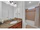 Well-lit bathroom featuring a marble countertop vanity and shower-tub combination with tile surround at 866 Coopers Ridge Sw Path, Grayson, GA 30017