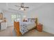 Inviting bedroom with a rustic wood bed frame, a ceiling fan, and a large window with backyard views at 866 Coopers Ridge Sw Path, Grayson, GA 30017