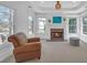 Cozy sitting area with a fireplace, large windows, and a comfortable armchair in the primary bedroom at 866 Coopers Ridge Sw Path, Grayson, GA 30017