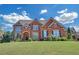 Beautiful two-story brick home with lush green lawn and manicured landscaping on a sunny day at 866 Coopers Ridge Sw Path, Grayson, GA 30017