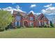 Beautiful two-story brick home with a lush green lawn and professional landscaping under a bright sky at 866 Coopers Ridge Sw Path, Grayson, GA 30017