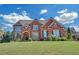 Imposing two-story brick home with manicured lawn, arched entryway, and stately curb appeal at 866 Coopers Ridge Sw Path, Grayson, GA 30017