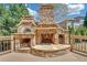 Outdoor stone fireplace, pizza oven, and wood storage on a wooden deck create an inviting space for entertaining at 866 Coopers Ridge Sw Path, Grayson, GA 30017