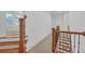 Upstairs hallway with carpet, hardwood staircase, wrought iron railings, and doorway into an adjacent room at 866 Coopers Ridge Sw Path, Grayson, GA 30017