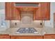 Close-up of the gourmet kitchen featuring a stainless steel gas cooktop and custom cabinetry at 866 Coopers Ridge Sw Path, Grayson, GA 30017