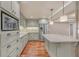 Well-lit kitchen with gray cabinets, stainless steel appliances, tile backsplash, and a granite countertop island at 866 Coopers Ridge Sw Path, Grayson, GA 30017