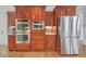 Modern kitchen with stainless steel refrigerator, double ovens and custom wood cabinets at 866 Coopers Ridge Sw Path, Grayson, GA 30017