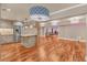 Spacious living room featuring hardwood floors, a modern light fixture, and a kitchen island with stainless steel appliances at 866 Coopers Ridge Sw Path, Grayson, GA 30017