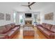 Bright living room featuring a stone fireplace, ceiling fan, and large windows providing ample natural light at 866 Coopers Ridge Sw Path, Grayson, GA 30017