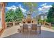Outdoor stone fireplace with a dining area surrounded by trees, creating an ideal space for gatherings and outdoor enjoyment at 866 Coopers Ridge Sw Path, Grayson, GA 30017