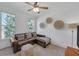 Bright sitting room with natural light from two windows and a comfortable L-shaped couch at 866 Coopers Ridge Sw Path, Grayson, GA 30017