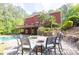 Luxurious backyard with a pool, hot tub, fire pit area, and lush greenery creating a private oasis at 1459 Harris Rd, Lawrenceville, GA 30043