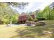 Expansive backyard with a pool, patio, tiered landscaping, and mature trees, creating a private oasis at 1459 Harris Rd, Lawrenceville, GA 30043