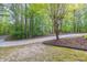 Long driveway leading to a home surrounded by lush trees and greenery at 1459 Harris Rd, Lawrenceville, GA 30043