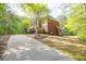 Exterior view of a brick home with a long driveway surrounded by lush trees at 1459 Harris Rd, Lawrenceville, GA 30043