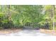 Private gated entrance surrounded by lush greenery and mature trees at 1459 Harris Rd, Lawrenceville, GA 30043