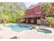 Backyard pool and spa with a brick patio and lush landscaping create a tranquil outdoor space at 1459 Harris Rd, Lawrenceville, GA 30043