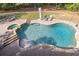 Aerial view of a backyard pool and spa with a stone patio and lush greenery at 1459 Harris Rd, Lawrenceville, GA 30043