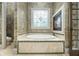Serene bathroom showcasing a soaking tub with fireplace, stylish tiles, and a decorative window at 3574 N Druid Hills Rd, Decatur, GA 30033