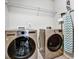 Convenient laundry room equipped with modern washer, dryer, and overhead storage at 1233 Miss Irene Ln, Lawrenceville, GA 30044