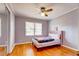 Cozy bedroom featuring hardwood floors, a ceiling fan, and natural light from a window at 241 Burke Cir, Mcdonough, GA 30253