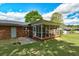 Exterior view of a brick home with a screened-in porch and a well-maintained lawn at 241 Burke Cir, Mcdonough, GA 30253