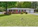Charming brick home featuring a well-manicured lawn, colorful flowers, and a two-car garage at 241 Burke Cir, Mcdonough, GA 30253
