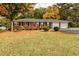 Charming brick home featuring a well-manicured lawn with colorful fall foliage at 241 Burke Cir, Mcdonough, GA 30253