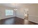 Elegant dining room with chandelier, dark wood floors, and views to the kitchen at 4500 Nocohoma Bnd, Douglasville, GA 30135