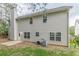 Back exterior view of a multi-story home with vertical siding, a patio, and a chimney at 4500 Nocohoma Bnd, Douglasville, GA 30135