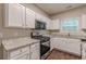 Stylish kitchen boasts granite countertops, white cabinets, stainless appliances, and hardwood floors at 4500 Nocohoma Bnd, Douglasville, GA 30135