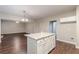 Kitchen island with granite countertops, white cabinets, and dark wood floors at 4500 Nocohoma Bnd, Douglasville, GA 30135